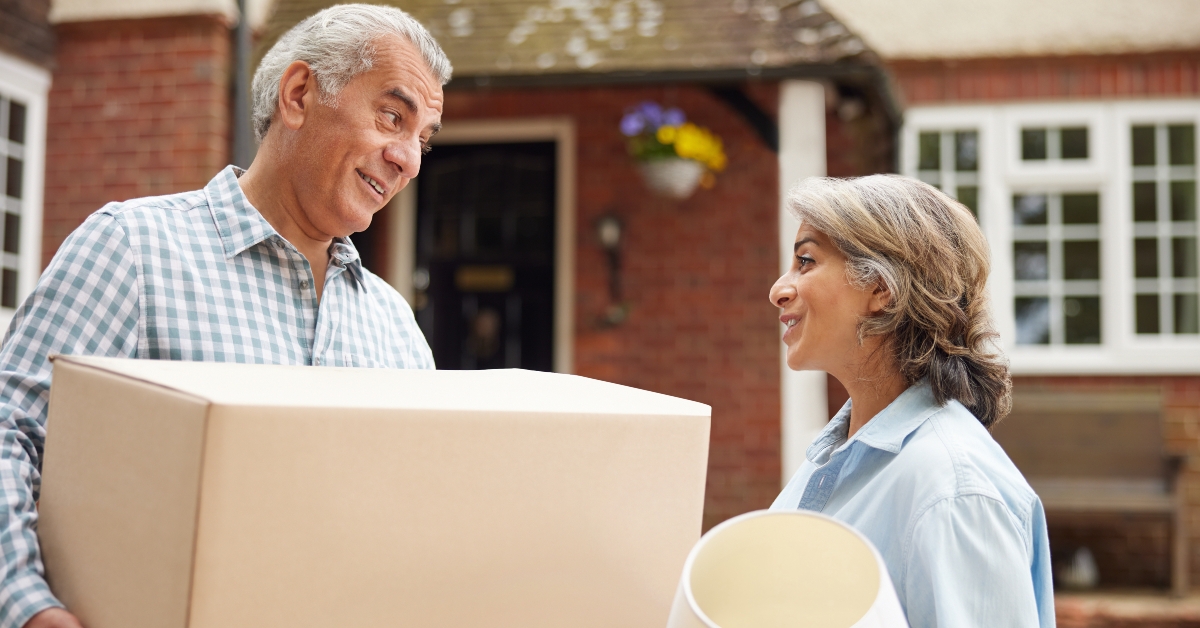 mature couple carrying boxes