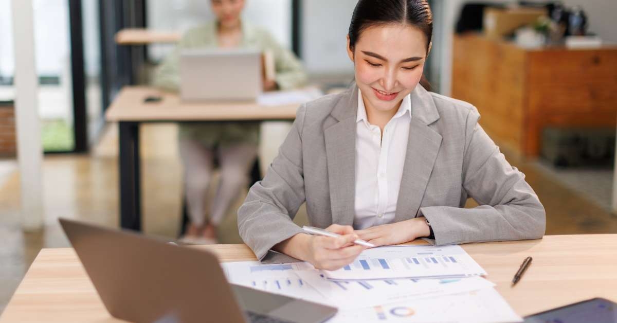 woman sitting at office desk working on laptop