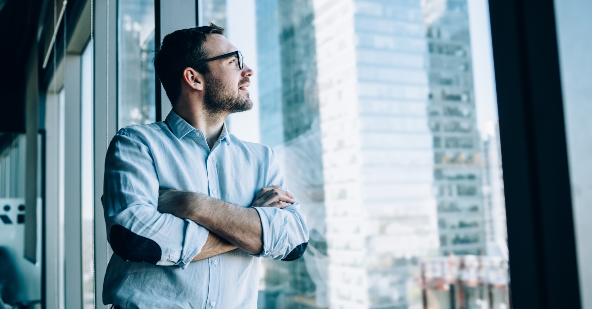 businessman standing near office window view