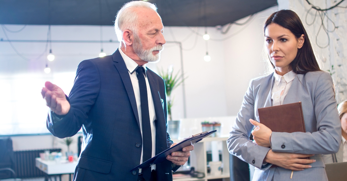senior man boss talking to female employee