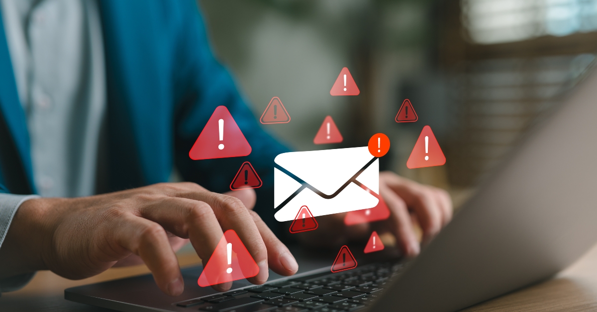 businessman typing on laptop with warning email icons