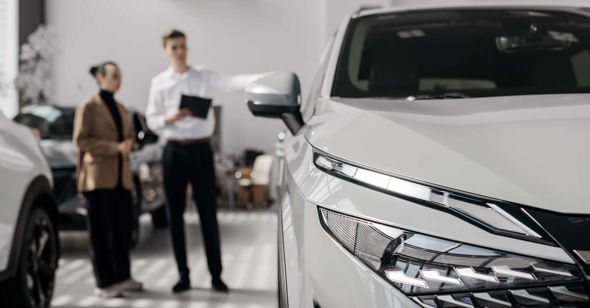 dealer in a modern car dealership advises a customer 