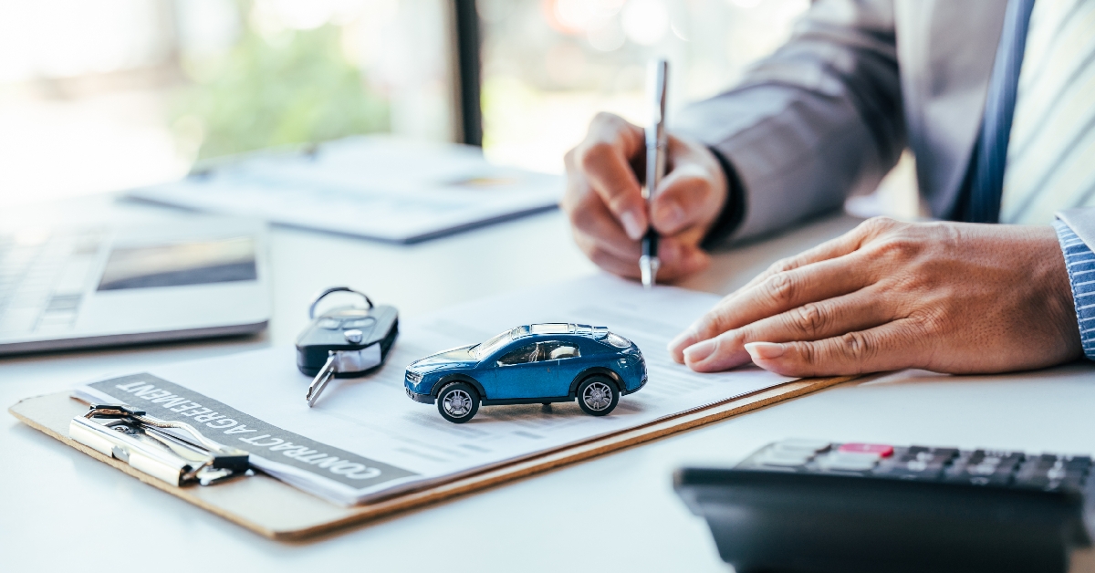 man signing car insurance document