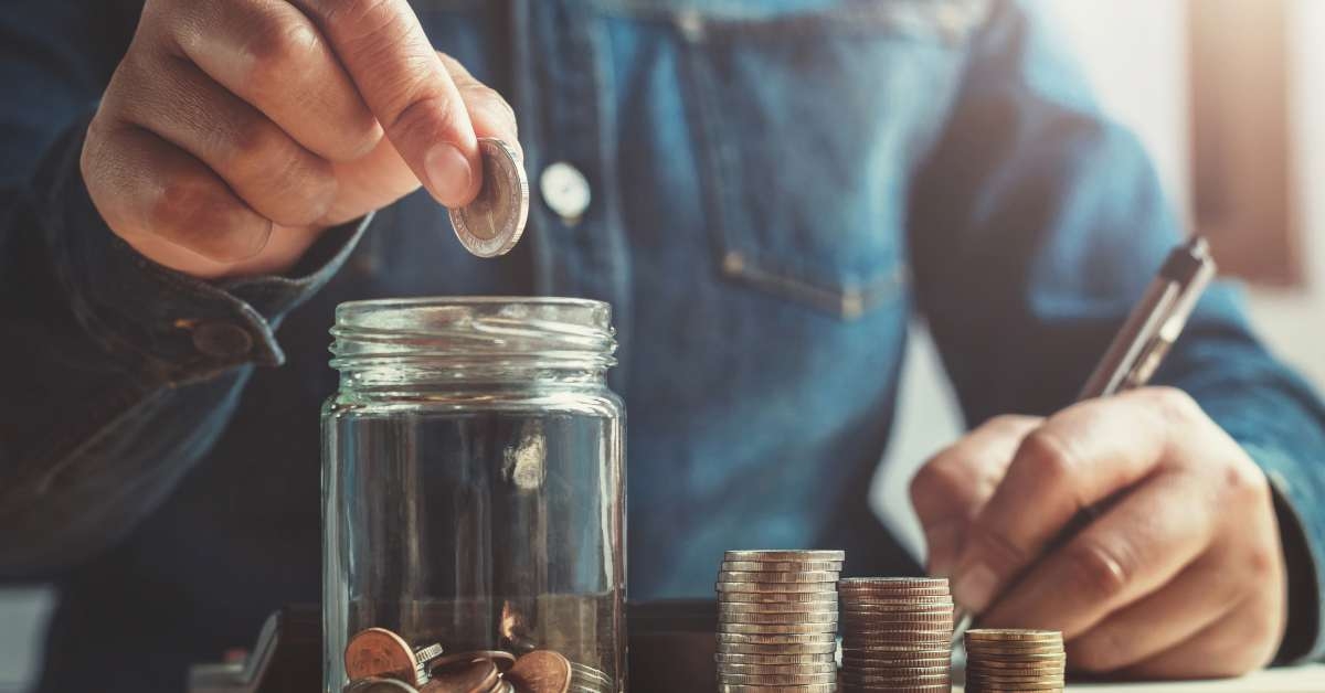 putting coins into jug glass