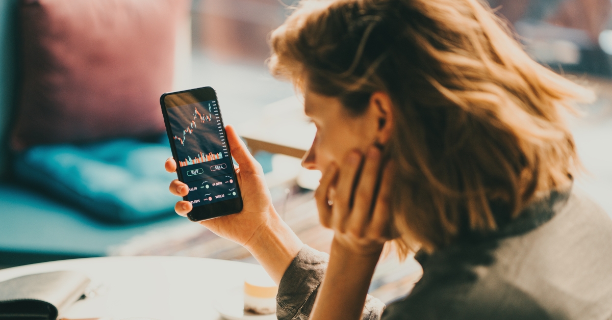 woman using mobile phone investing 