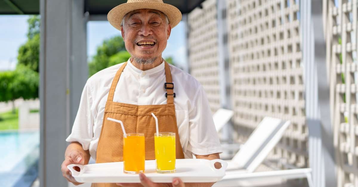 man wearing uniform serving beverage fruit juice