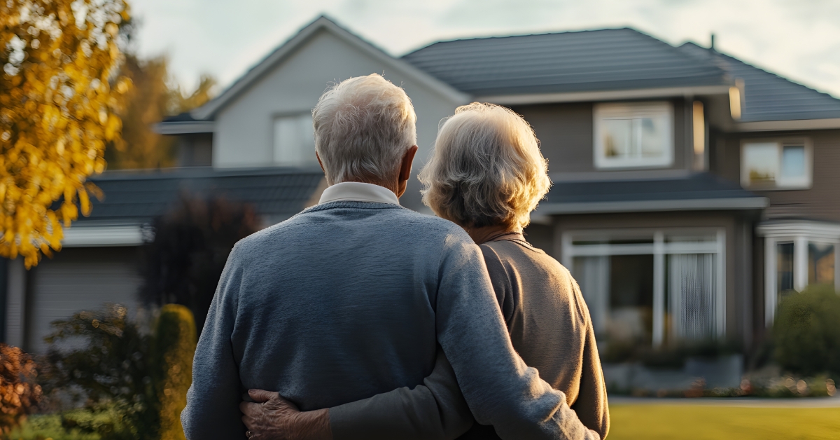 senior couple infront of their new house