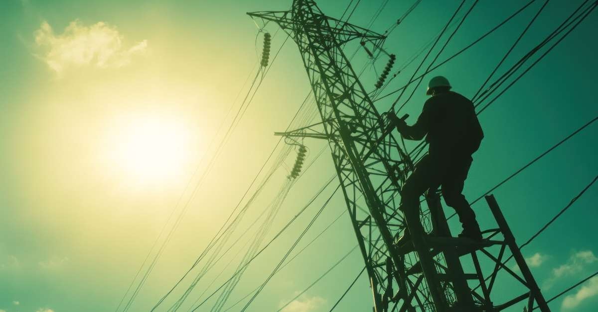 utulity worker climbs high voltage power tower