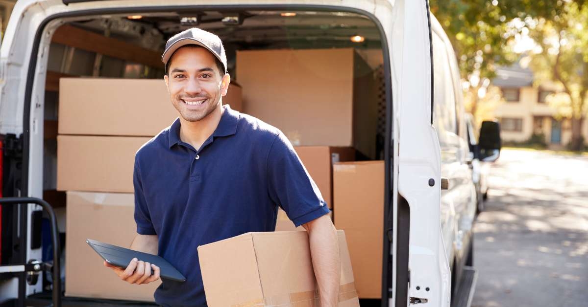 courier with digital tablet delivering package
