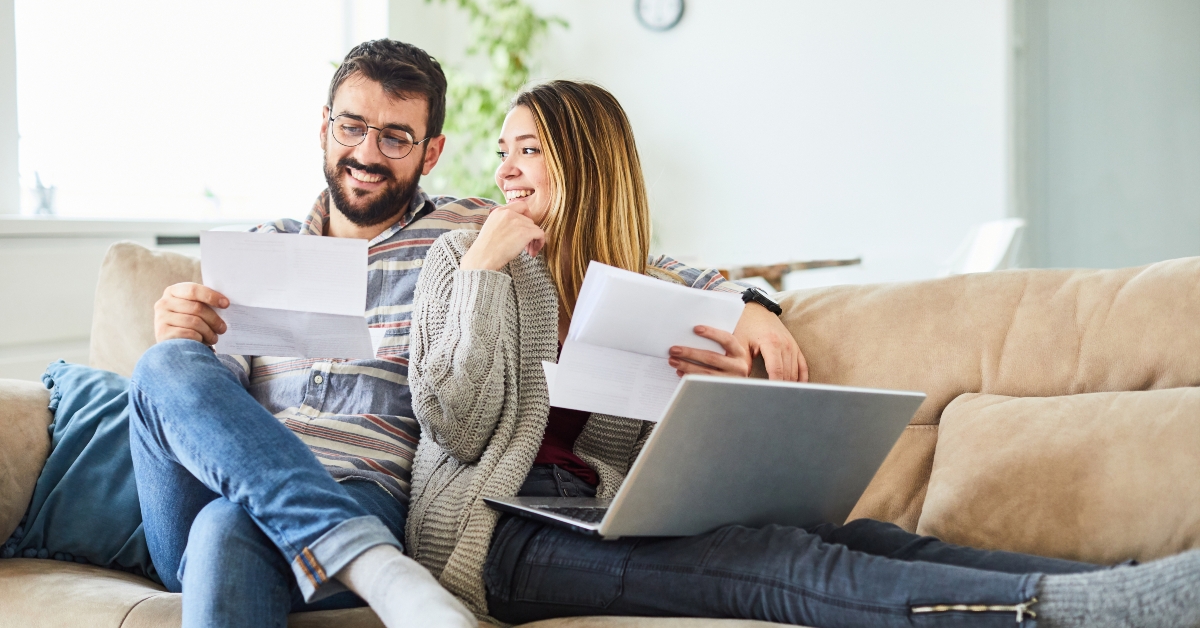 happy couple reading paper documents