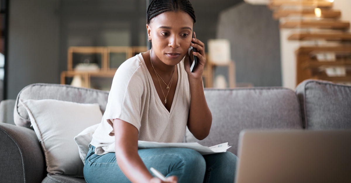 woman calling while writing on notes