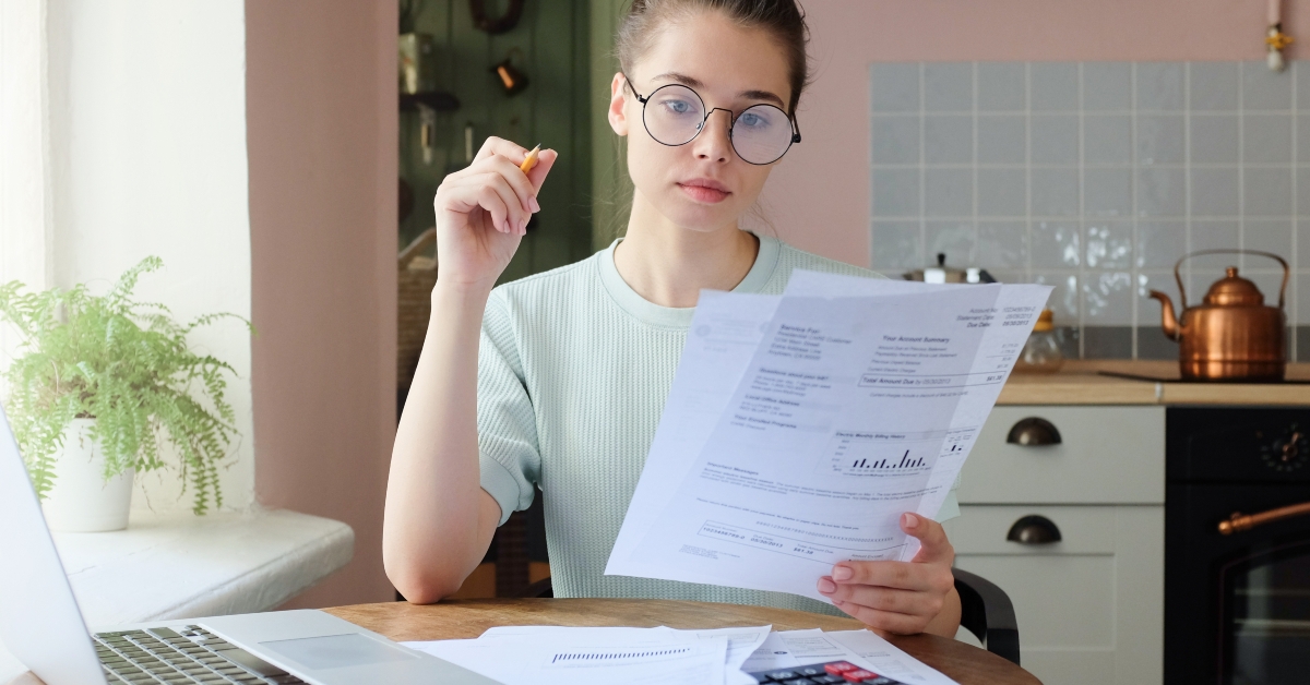 woman sitting at kitchen table filling application form
