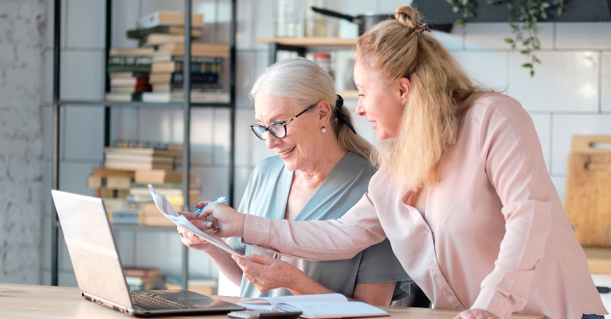 middle aged daughter helps her mother with documents