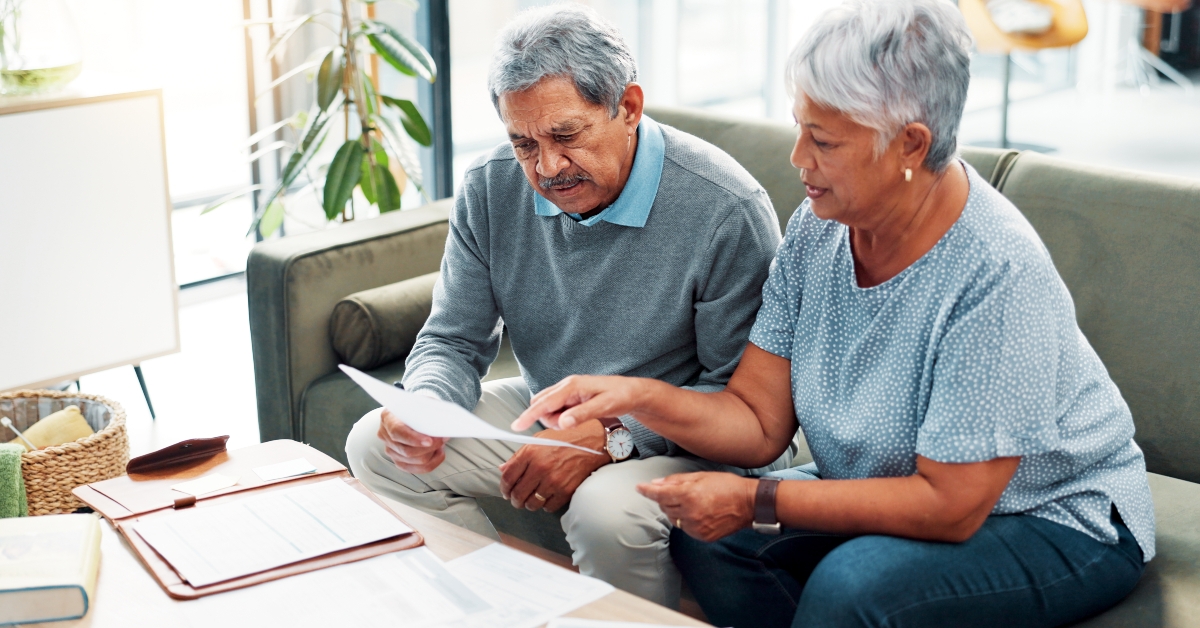 senior couple in home with debt
