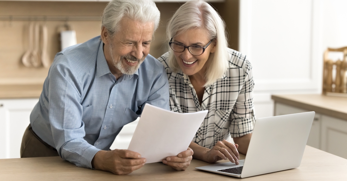 happy senior couple reading legal document