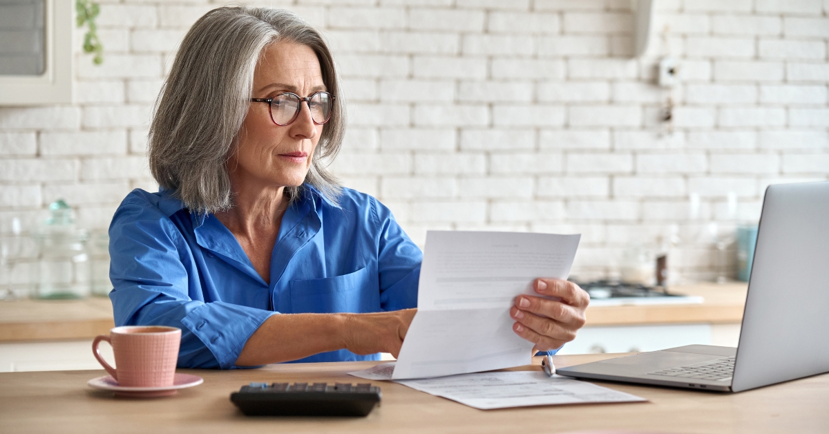 senior woman holding document calculating bills