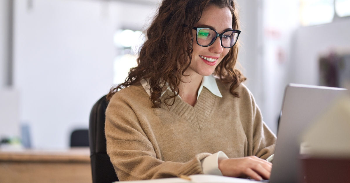 employee sitting at desk working on laptop