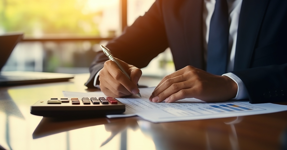businessman writing financial documents
