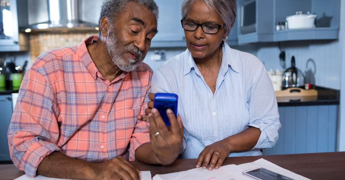 couple using calculator in kitchen