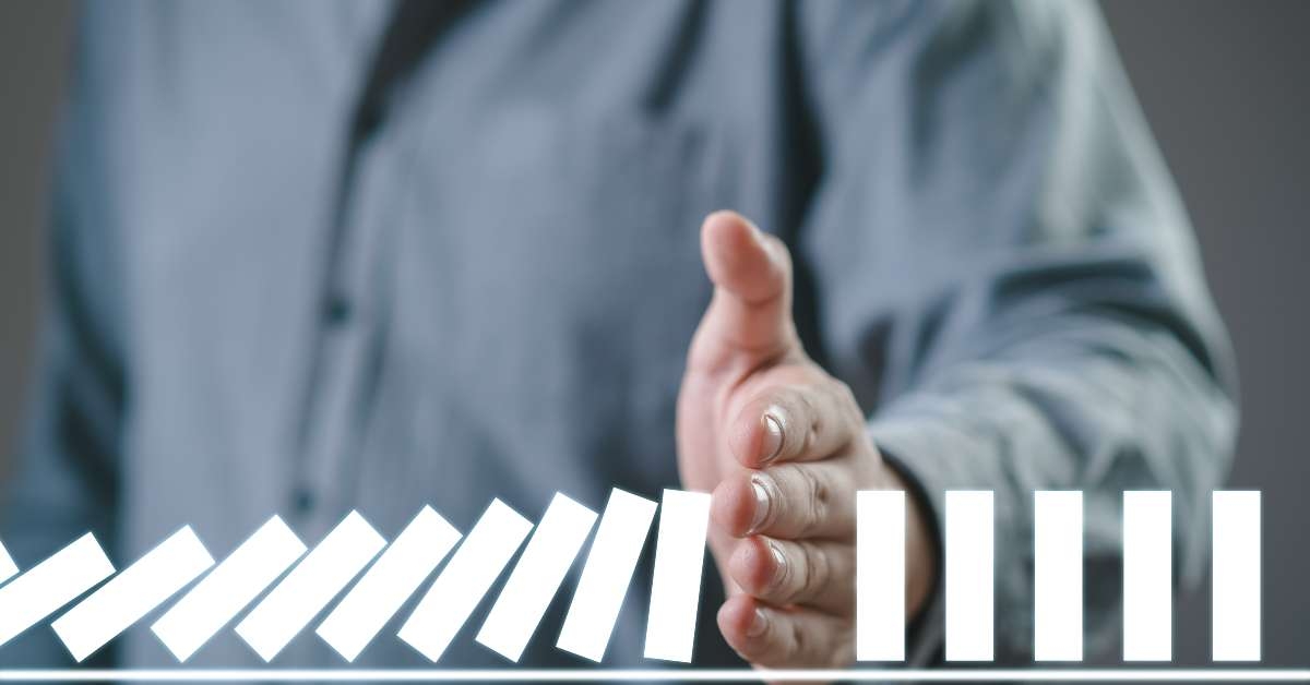 hand stopping the digital domino