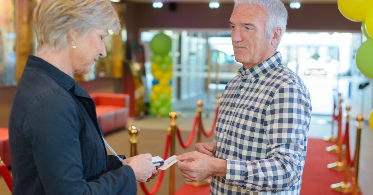 man passing ticket to woman