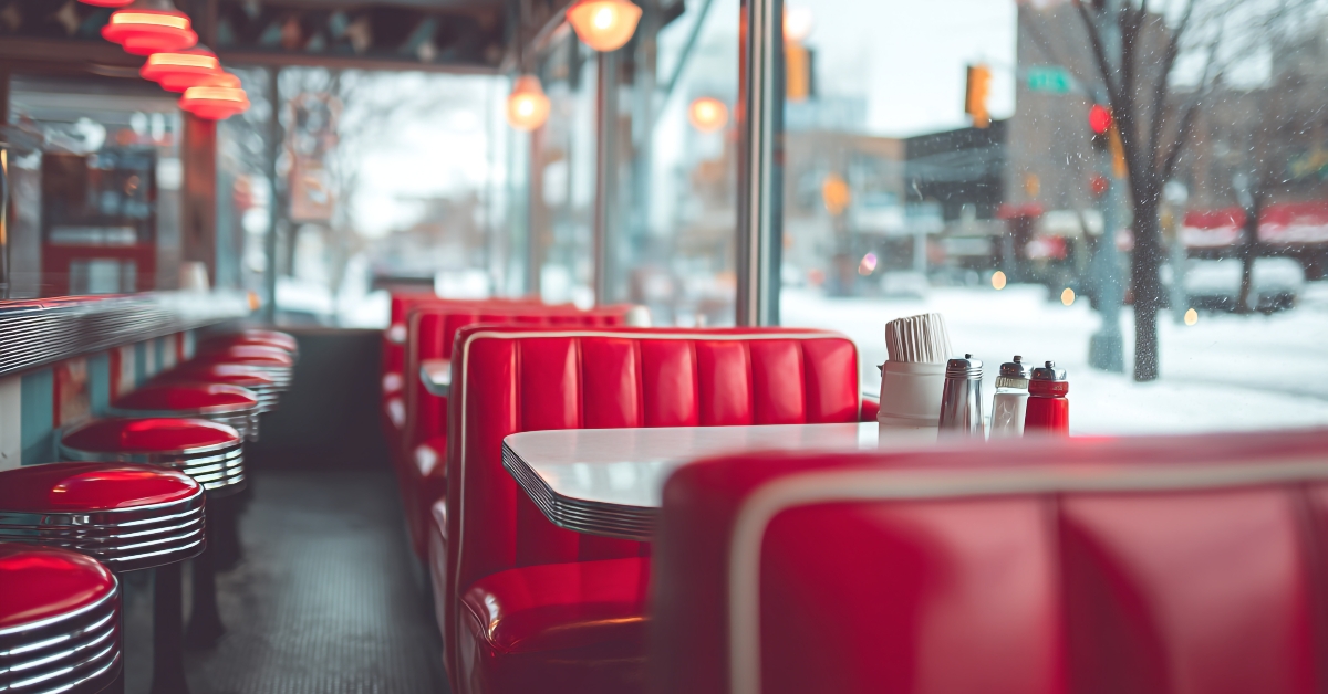 Interior view of a diner with red booths and stools