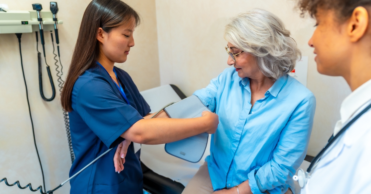 Nurse checking blood pressure of senior woman