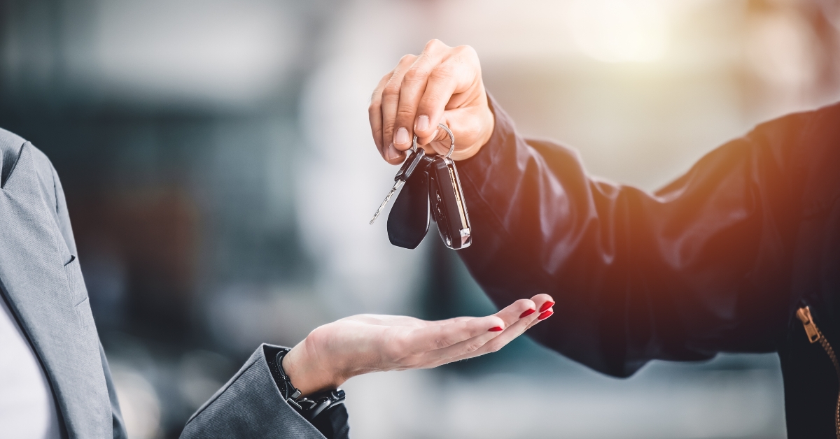 hand giving a car key