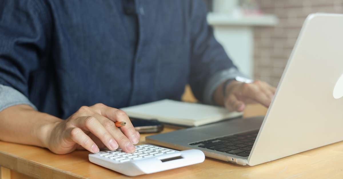 man hand use on calculator to check about debt bills pay monthly