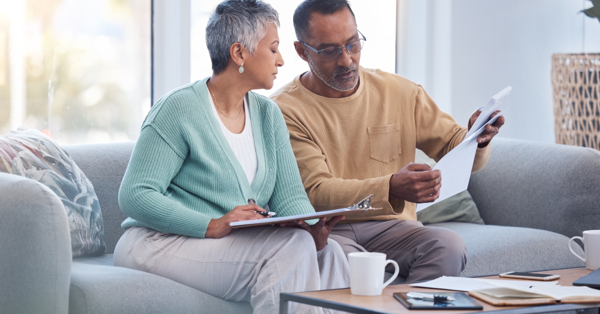 senior couple on sofa with bills