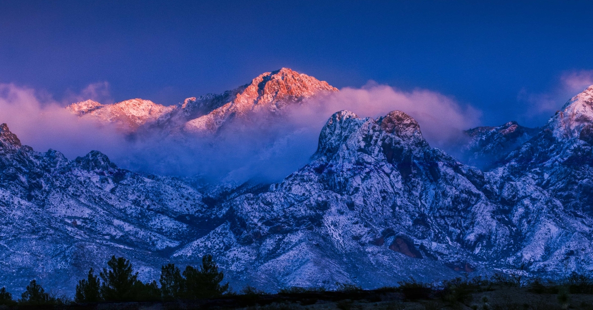 sun setting on snowy mountain peak
