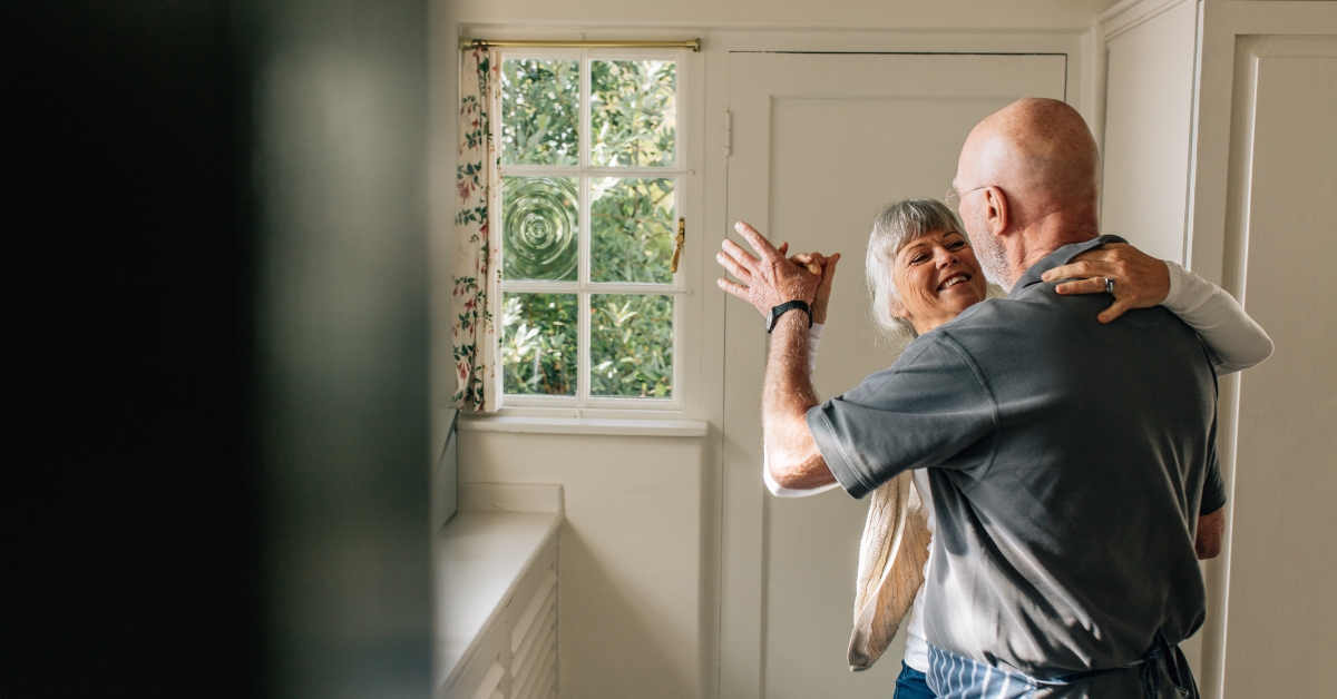Senior couple dancing at home