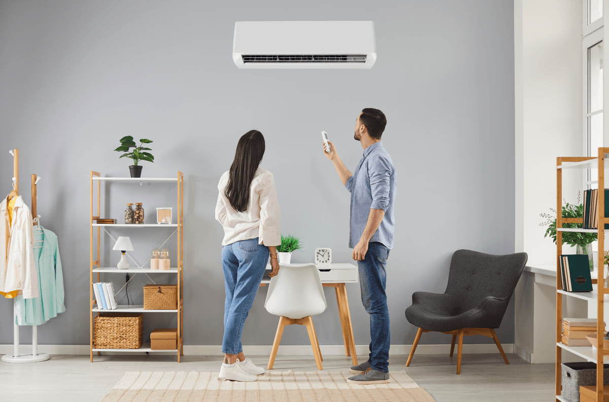 Couple standing in home with air conditioning unit mounted on wall