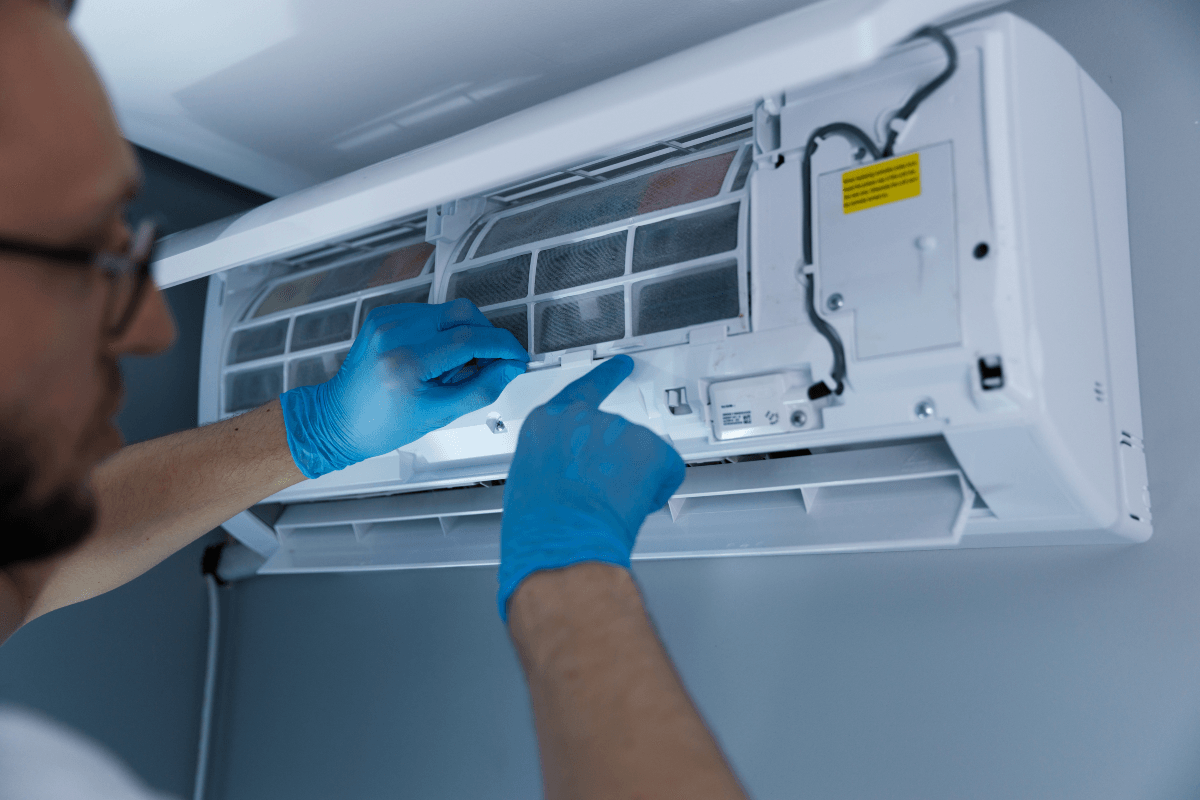 Technician maintaining a residential wall-mounted air conditioner