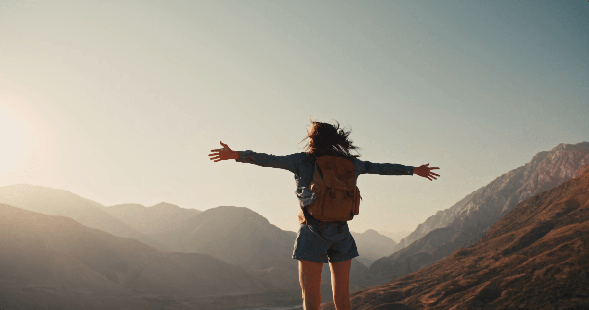 Woman standing on top of mountain after long hike