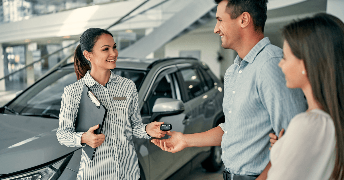 Young couple purchasing car in dealership