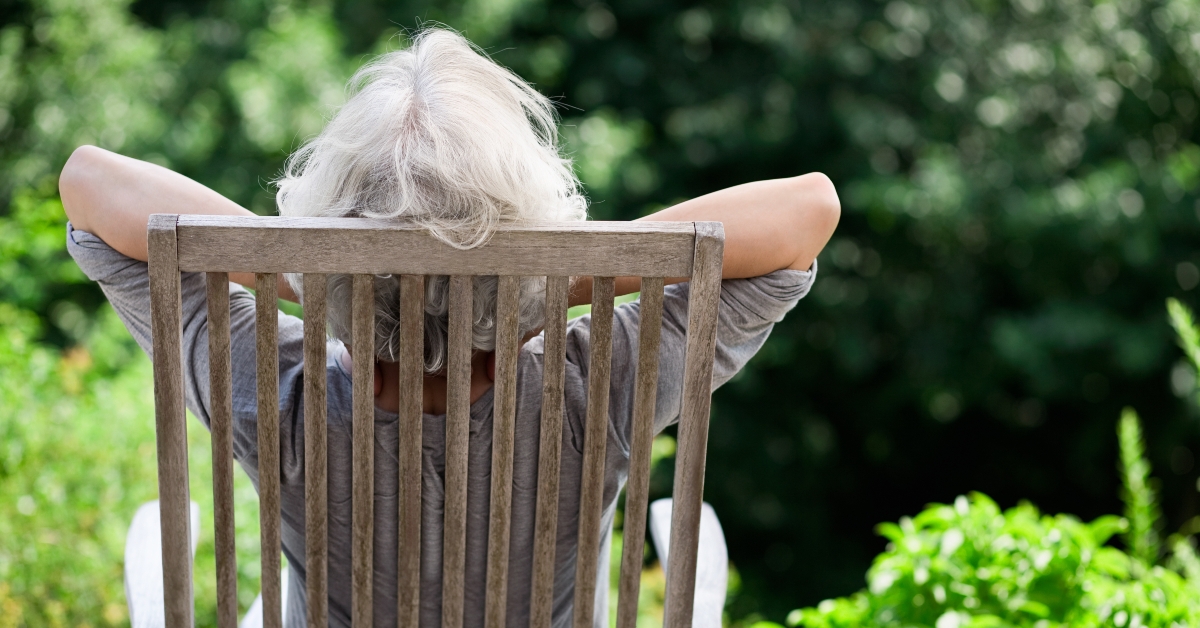 senior woman stretching on a wooden chair