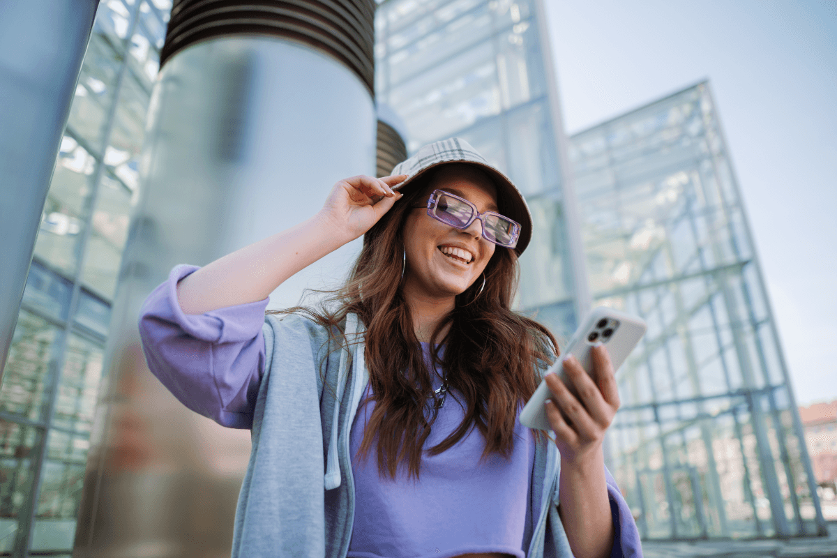 Young woman happily using banking app on cell phone, because nearly two-thirds of respondents (65%) value a great banking app over a nearby branch, with the average person now handling 88% of their banking digitally.