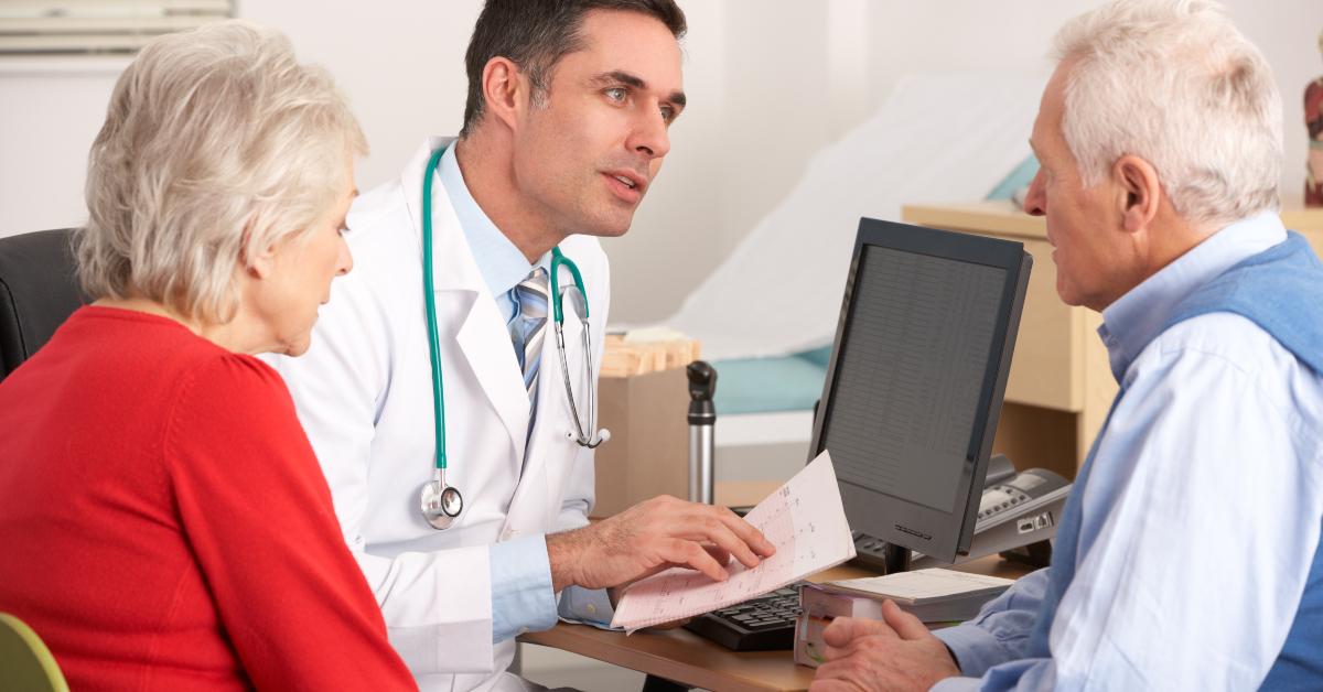 doctor talking to senior couple in surgery