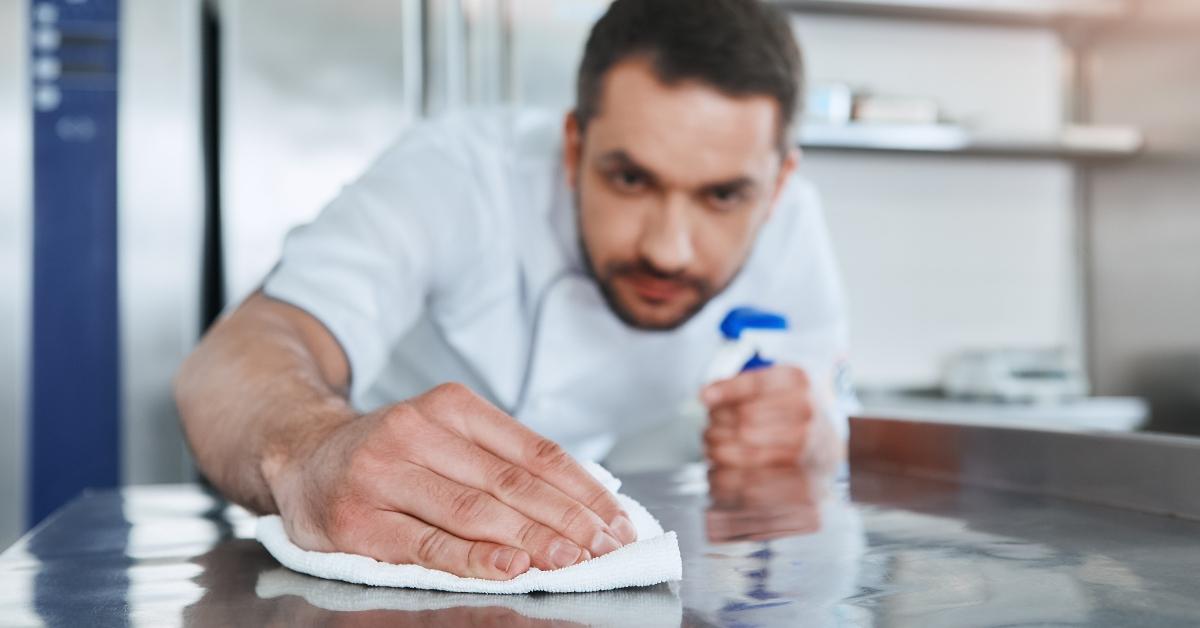 worker in restaurant kitchen cleaning down after service