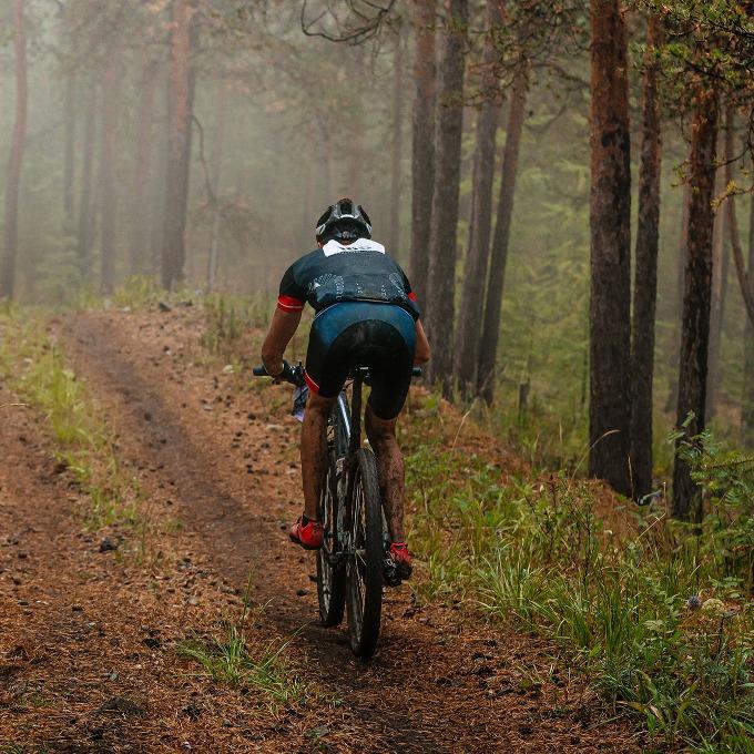 cyclist riding mountain bike on forest trail