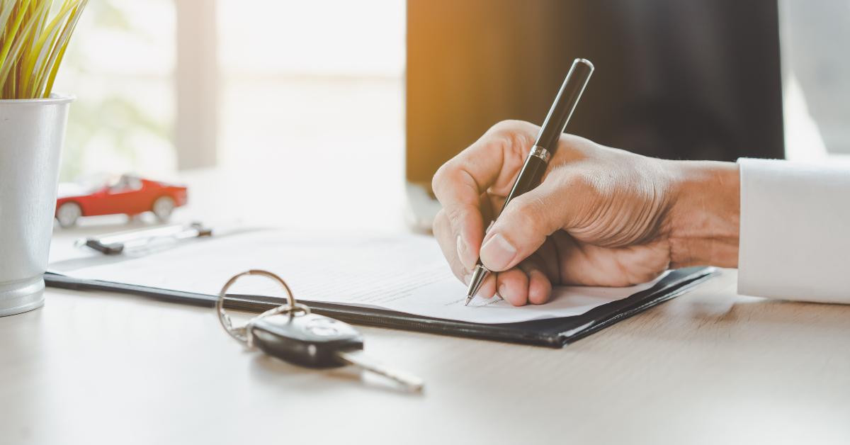 hands of client signing car lease form