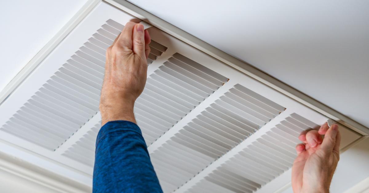 Man opening ceiling air vent