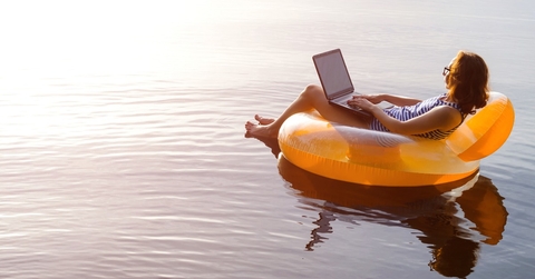 woman floating in lake with laptop