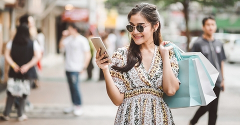 Woman carrying shopping bags and looking at her phone