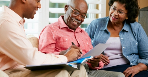 Senior couple reviewing documents with a salesperson