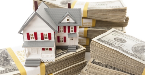 Toy house surrounded by money