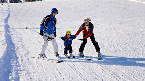 Family with young child skiing