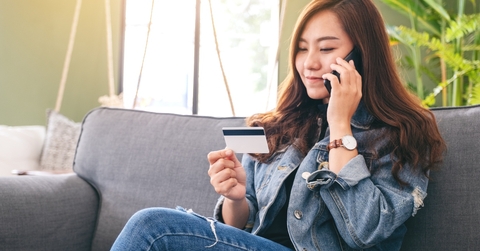 Woman talking on phone and holding credit card