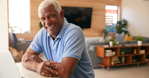 Man working on bills and smiling